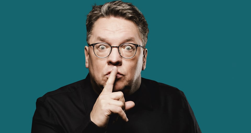Mann mit Brille vor blauem Hintergrund