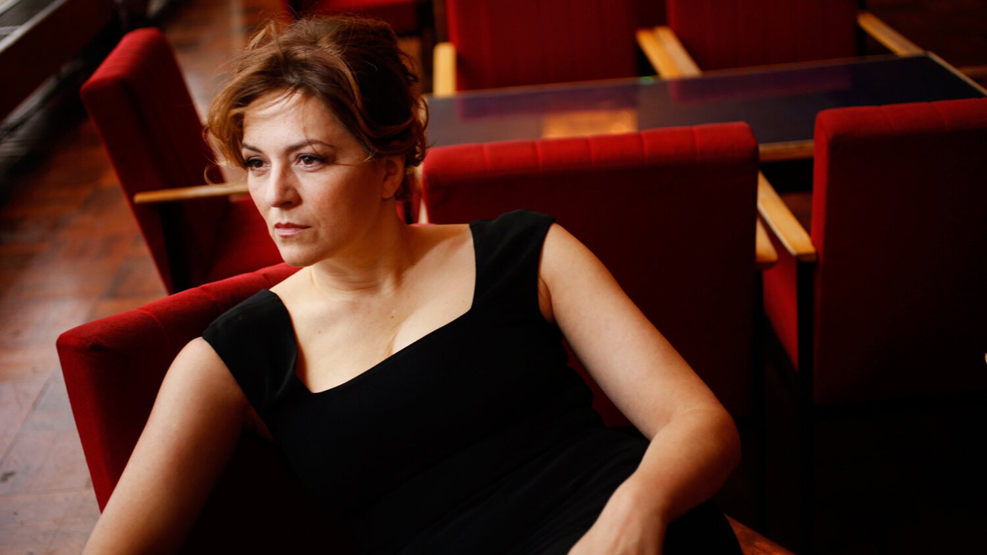 Foto für die Veranstaltung 'Enoch Arden Melodram von Richard Strauss' mit der Künstlerin Martina Gedeck, sitzend auf roten Stühlen