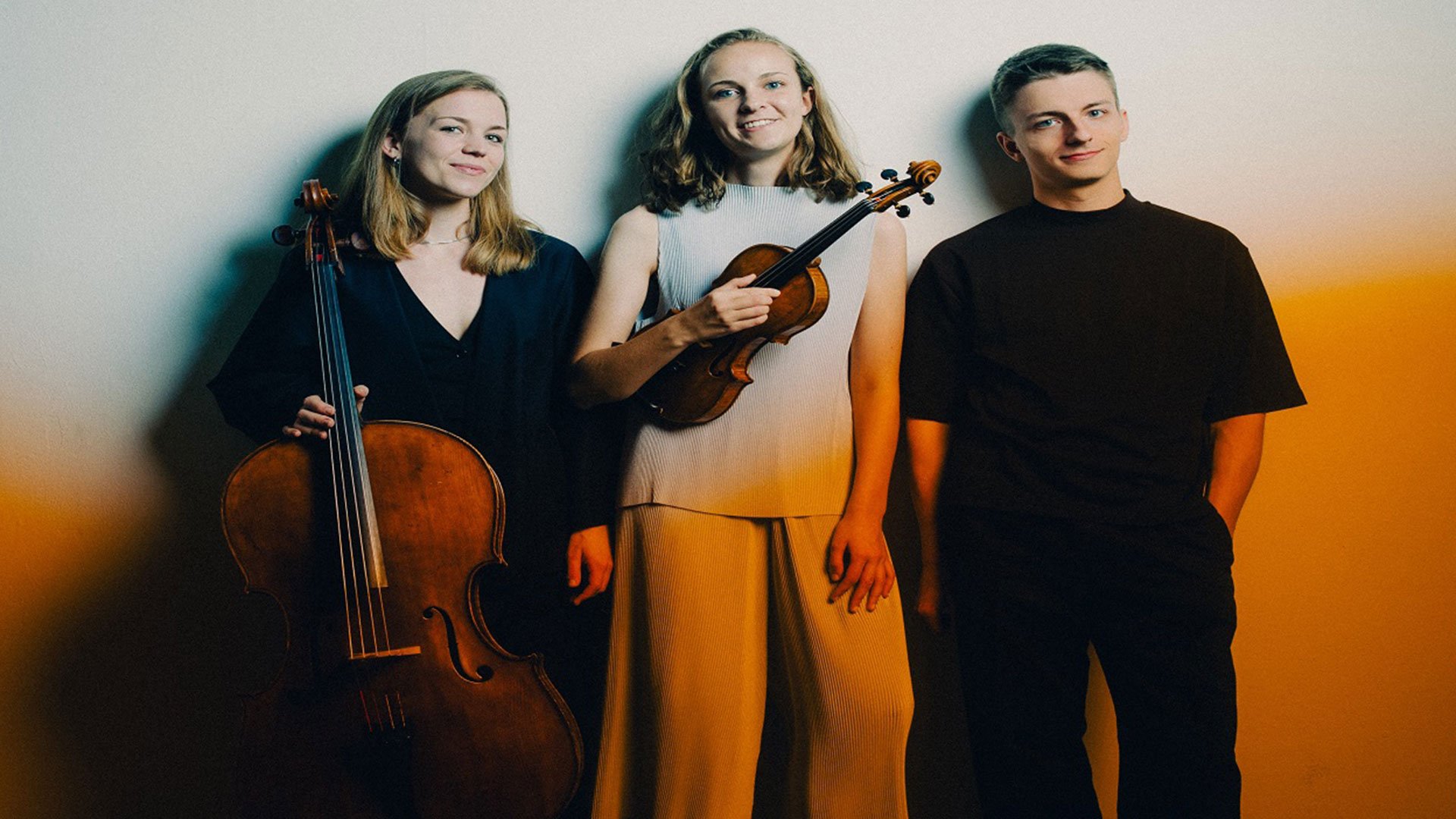 Eventfoto von Amelio Trio mit einem Gruppenbild des Trios und einem orangenen Fotoeffekt.