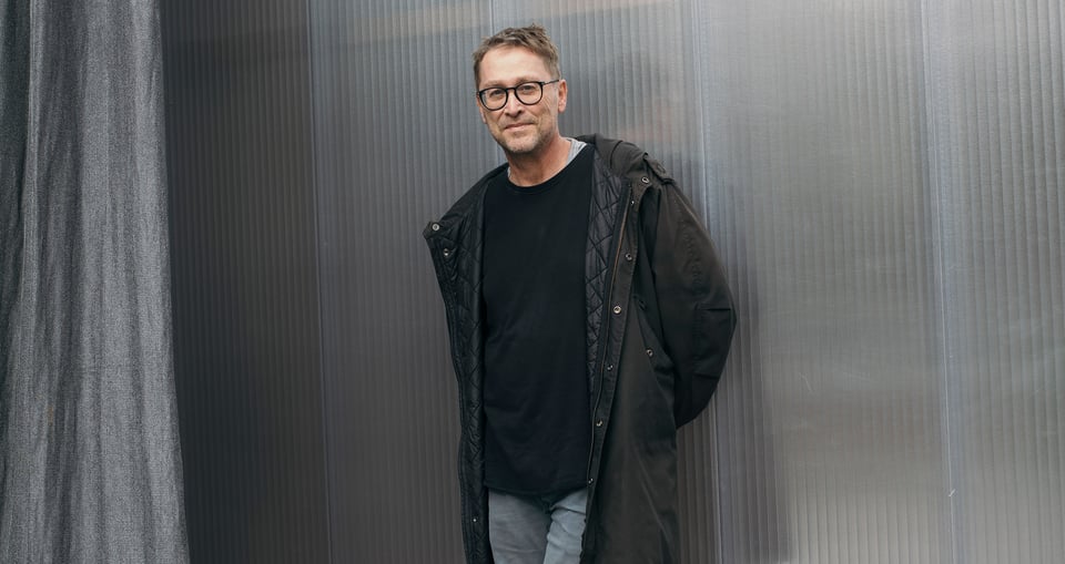Foto des Autors Jan Weiler, lässig an eine Wand gelehnt 