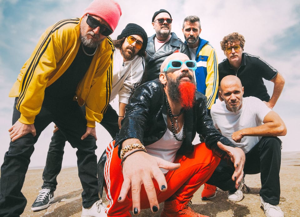 Foto der Band mit mehreren Mitgliedern in einer einsamen Landschaft, im Hintergrund nur der Himmel sichtbar