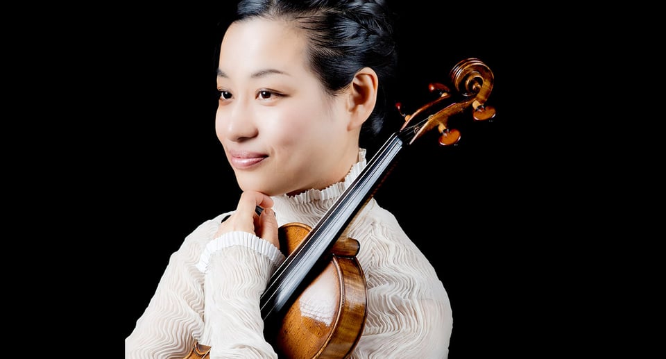 Dame in weisser Bluse mit Violine vor schwarzem Hintergrund