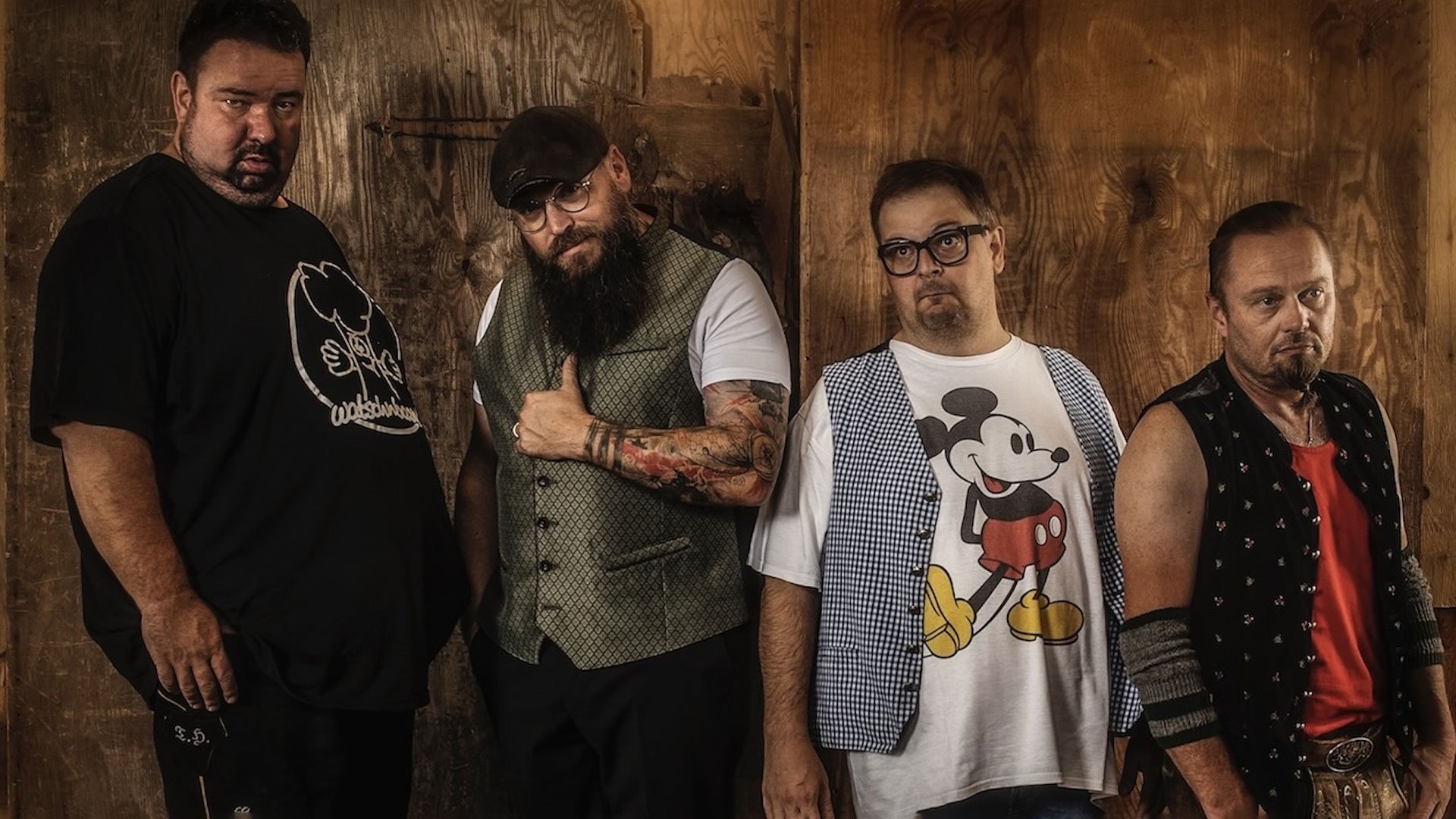 Veranstaltungsfoto von ‚Da Meier & Watschnbaam‘ mit vier Künstlern vor hölzerner Wand