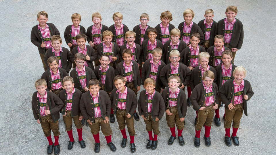 Gruppenbild des Tölzer Knabenchors in Tracht mit karierten Hemden und Lederhosen