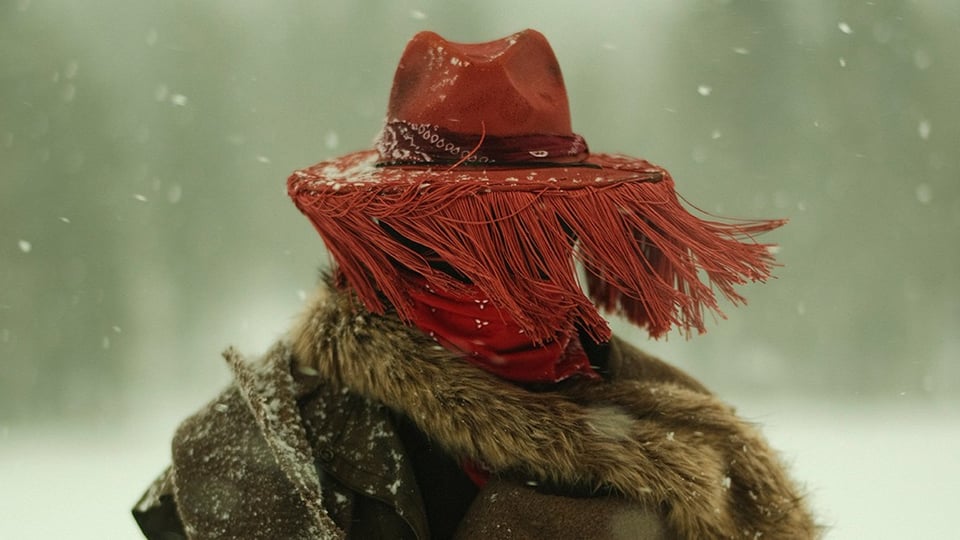 Eine person mit einem orangen Fransenut und Pelz