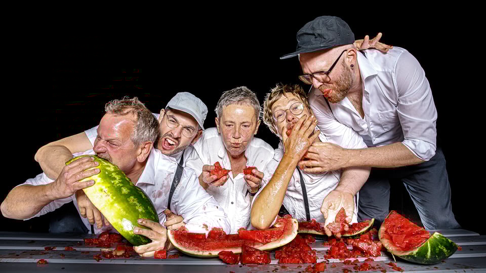 Foto der Musikgruppe 5/8erl in Ehr’n – 20 Jahre Wiener Soul, mit den Bandmitgliedern beim Wassermelone-Essen