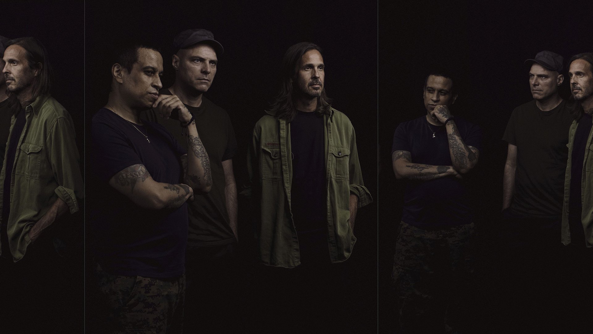 Mehrere Personen in dunkler Kleidung und einer Spiegelung 