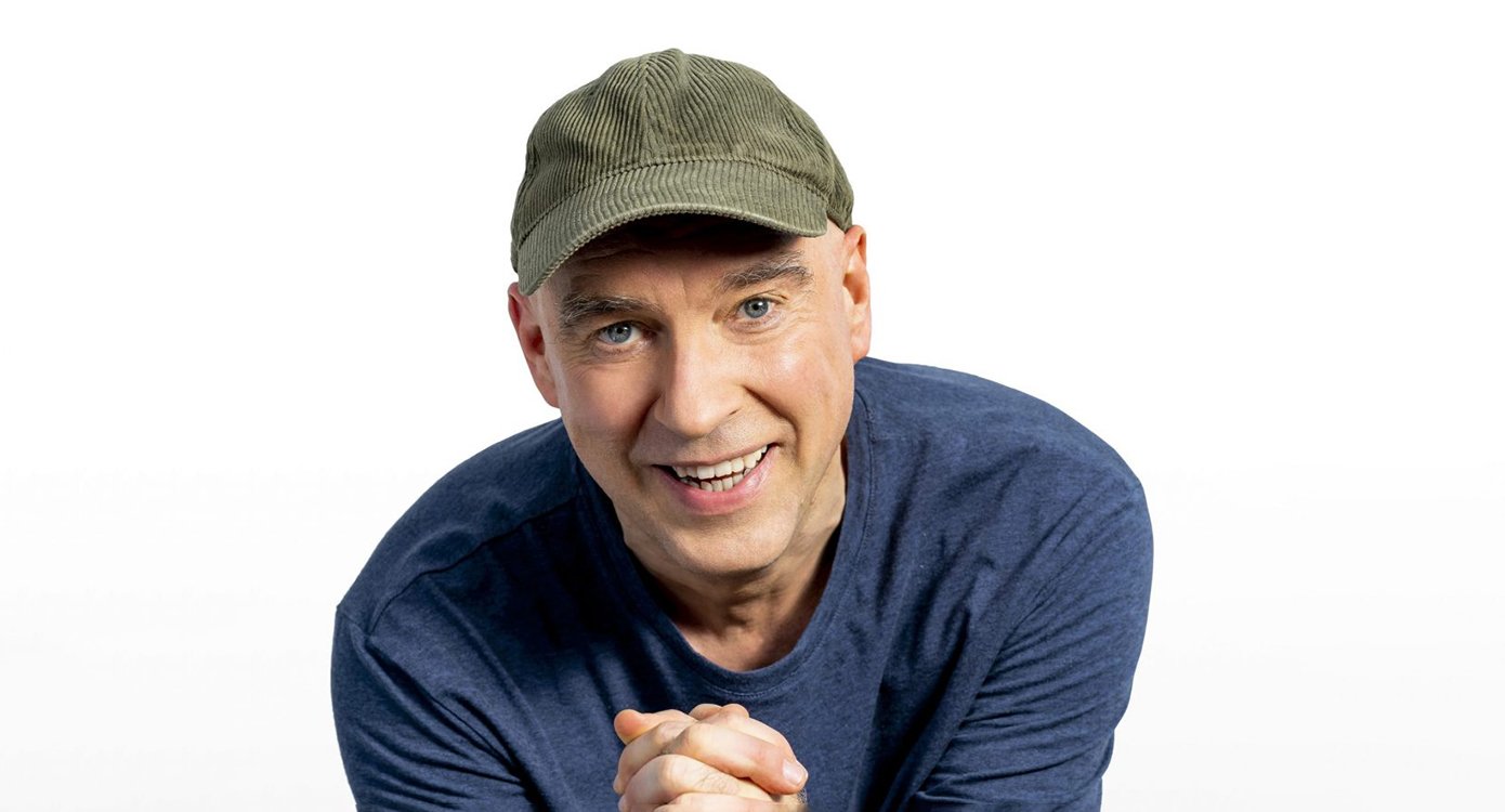 Foto eines Mannes mit Kappe vor weißem Hintergrund.
