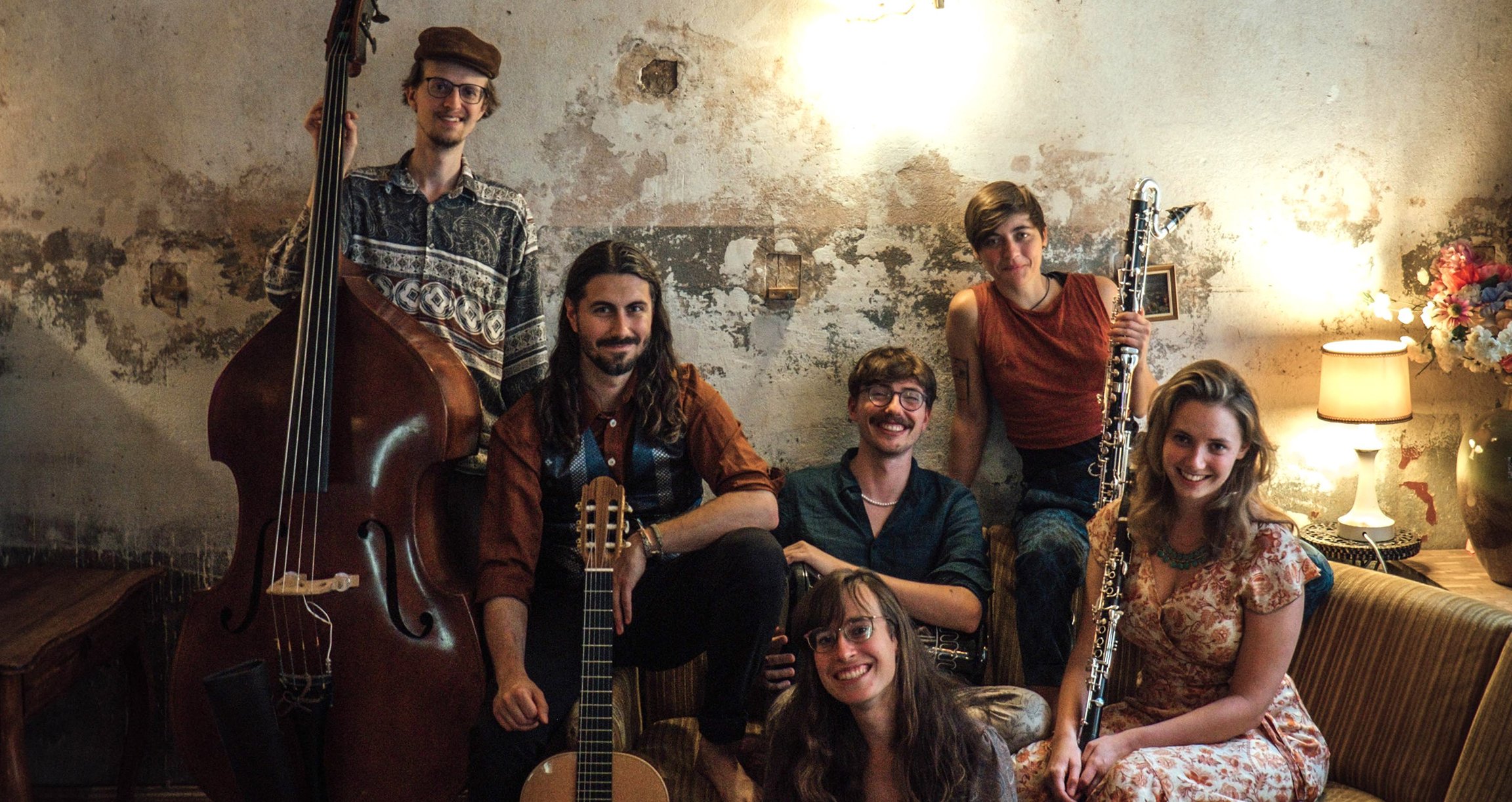 Sechs Personen mit Instrumenten und fabriger Kleidung