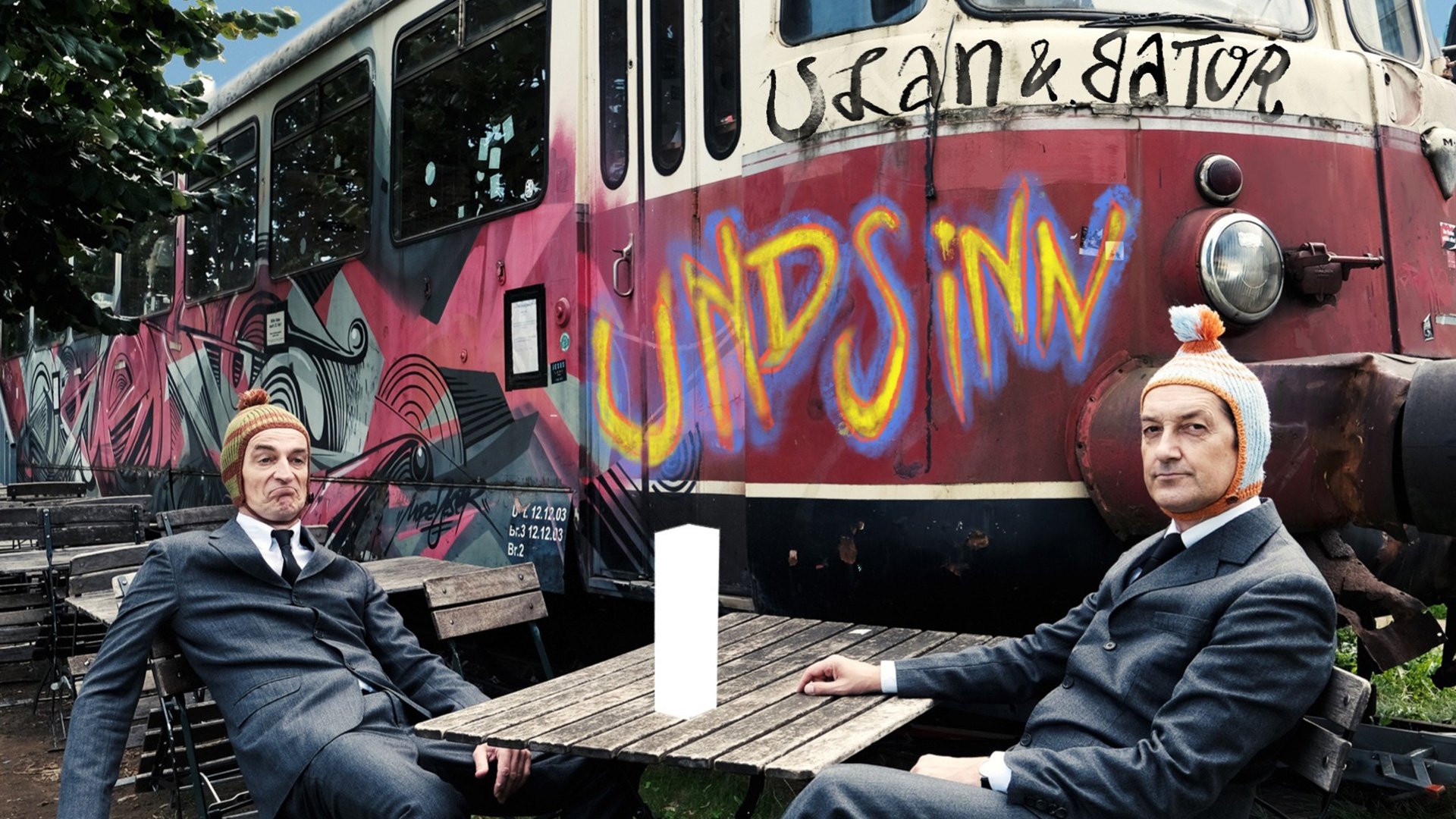 Foto für das Event Ulan & Bator: Undsinn mit einem Waggon im Hintergrund, auf dem ein Graffiti mit ihren Namen zu sehen ist.
