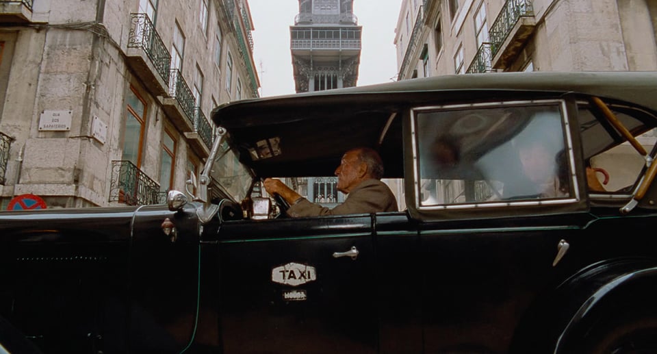 Älterer Taxifahrer in Oldtimer Taxi am Steuer sitzend