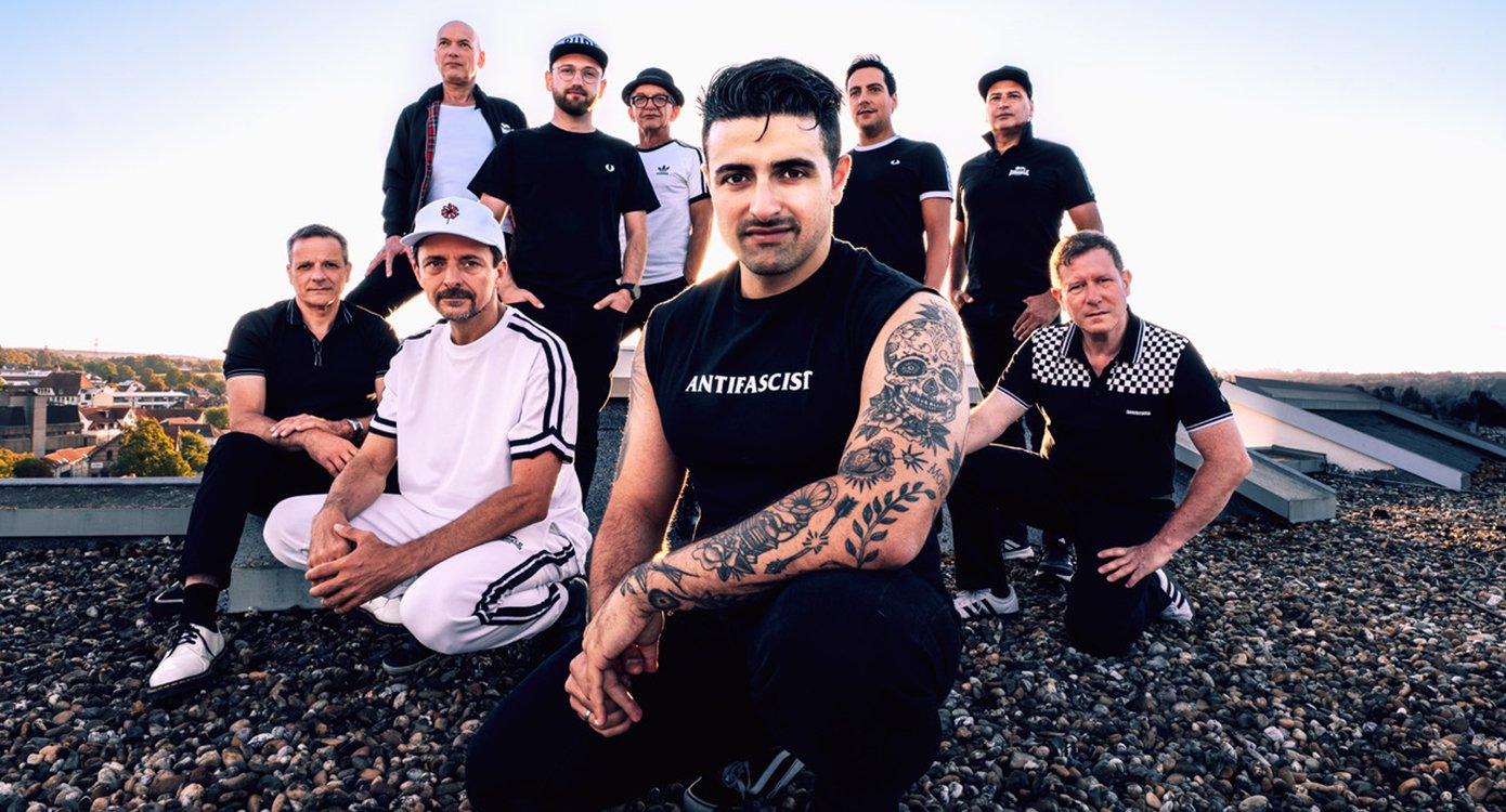 Die Band posiert unter freiem Himmel – ein Gruppenfoto in natürlicher Umgebung
