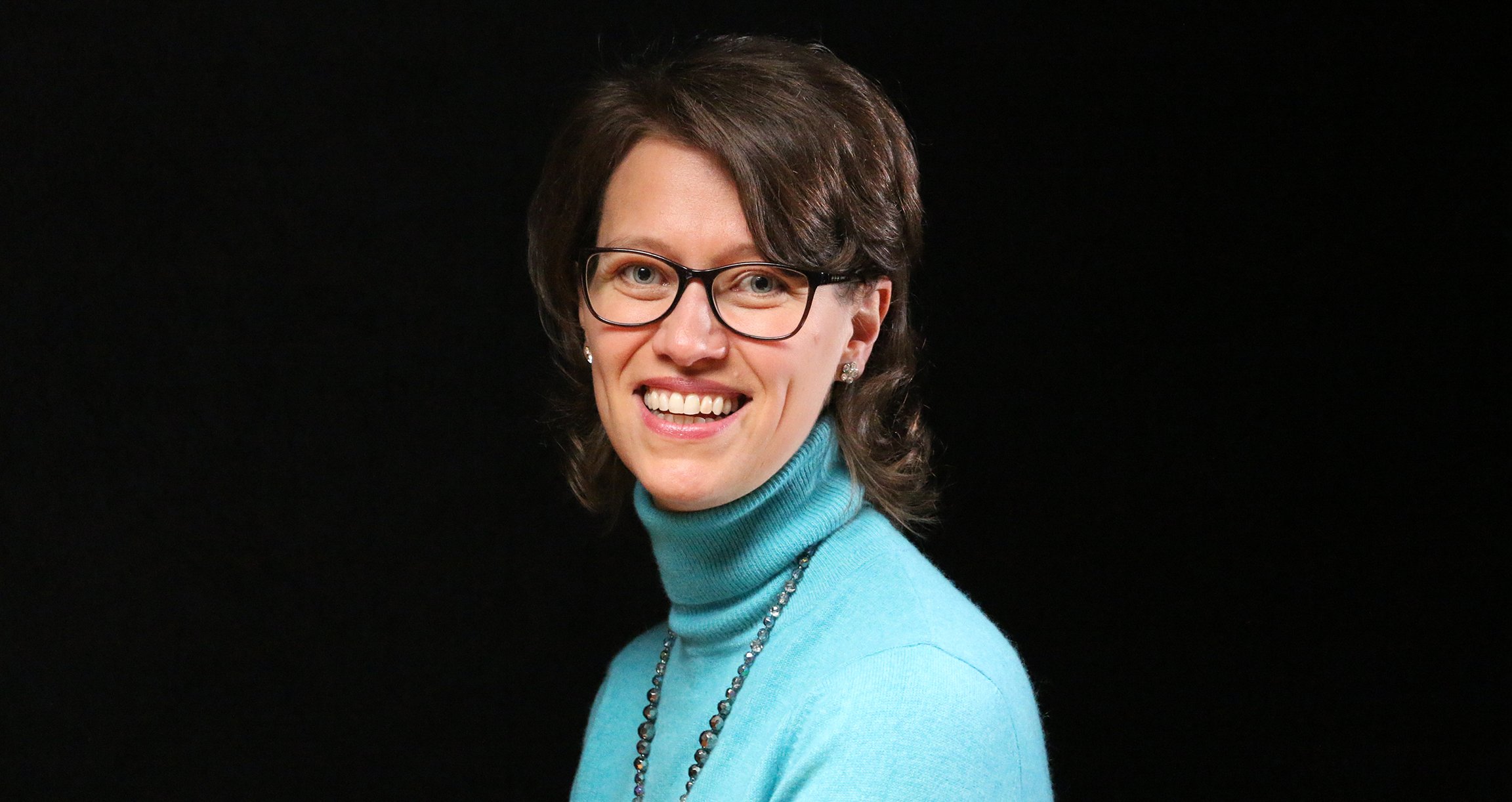 Dame in hellblauem Pullover vor dunklem Hintergrund