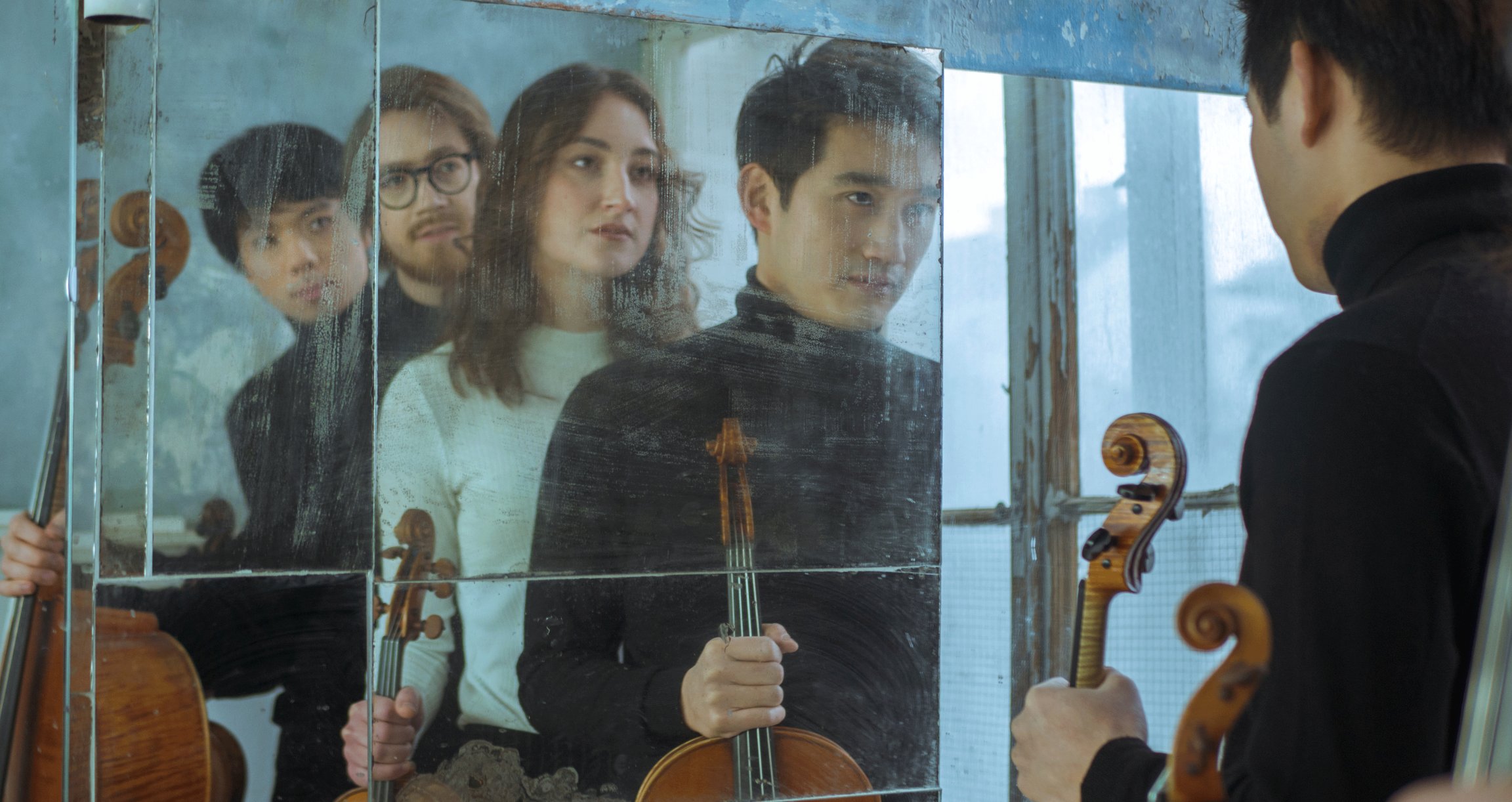 Foto der Band mit Instrumenten, die sich in einem Spiegel spiegeln