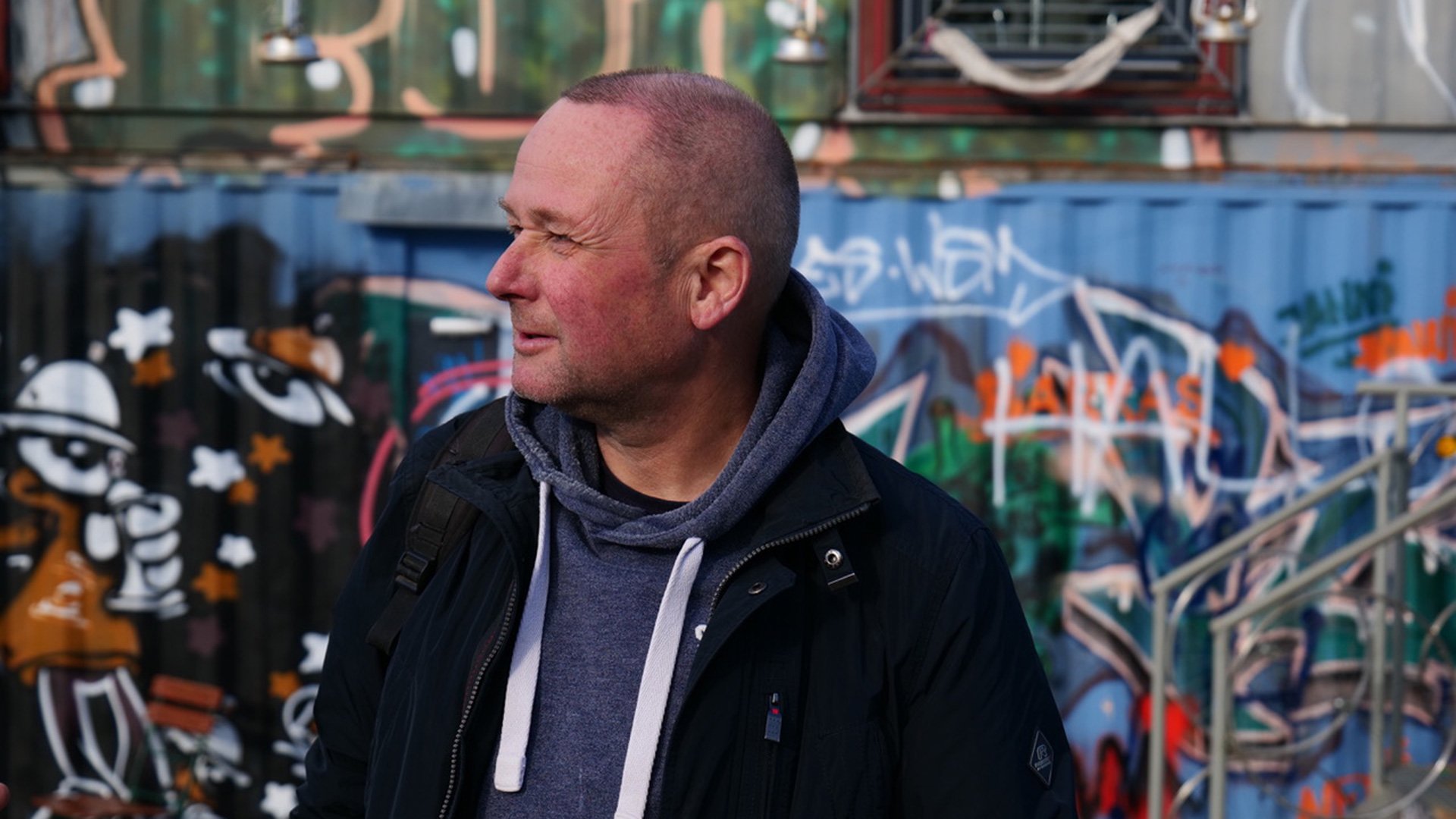 Foto für das Event ‚Prost & Prosa‘ mit Volker Camehn, vor einem Hintergrund mit Graffiti