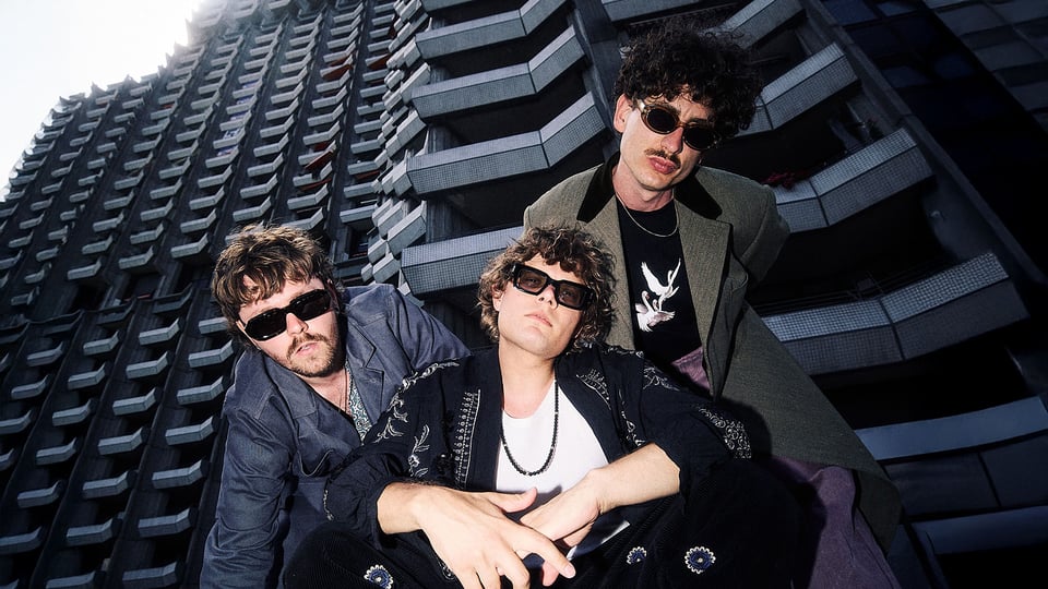 Drei Männer vor einem Hochhaus