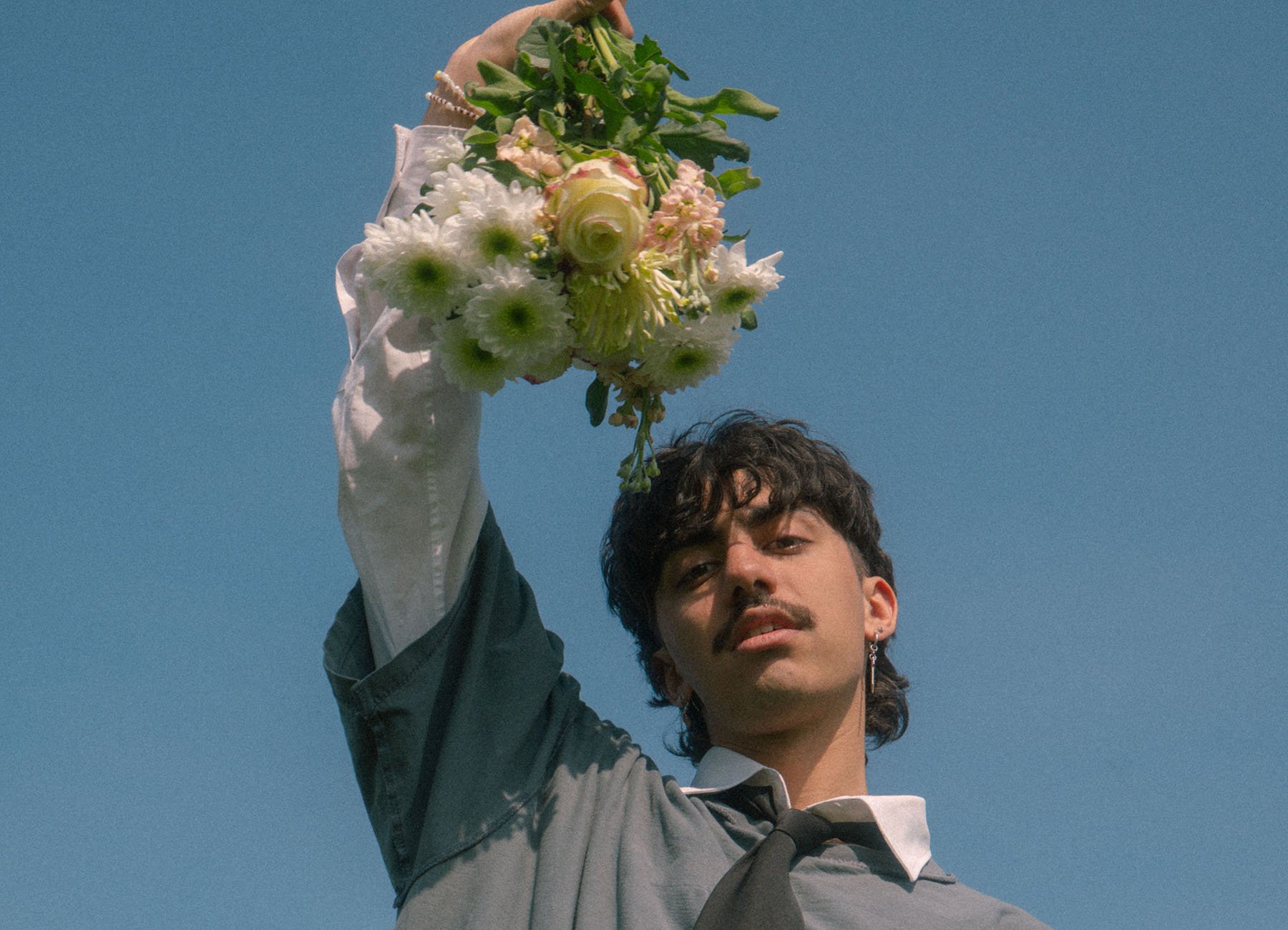 Mann hält Arm hoch mit Blumenstrauß in der Hand