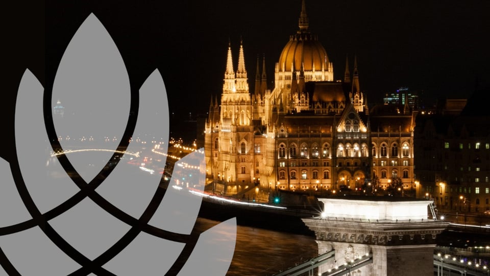 Ein Bild des Budapester Parlaments bei Nacht mit Logo des Opera Augusta links