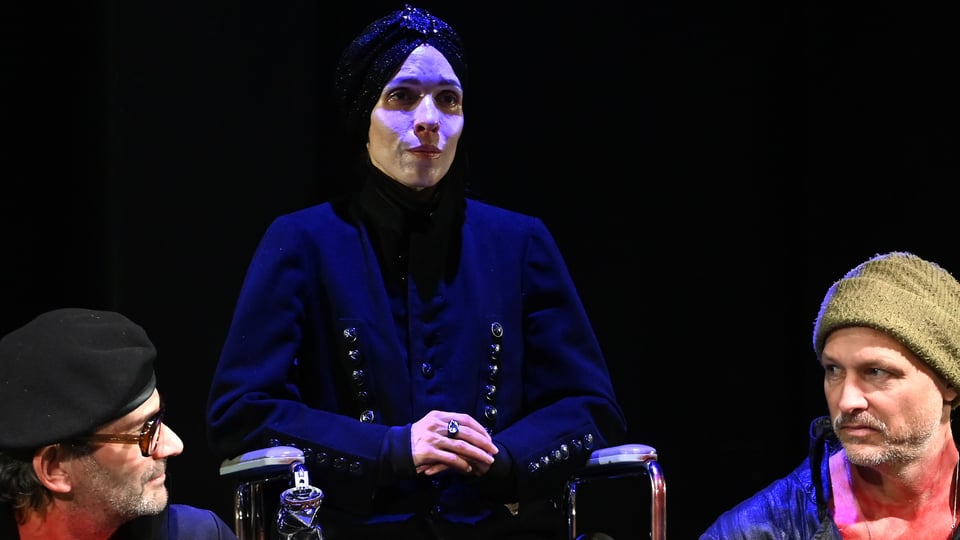 Drei Darsteller*innen auf der Bühne in dunklem Licht aus dem Theaterstück Corolian von William Shakespeare 