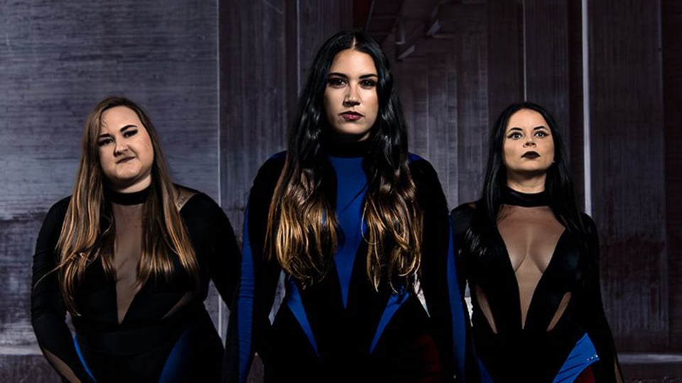 Ein Foto der drei Künstlerinnen von der Band The Gems vor grauem Hintergrund