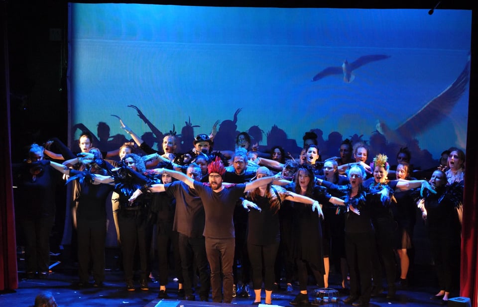 Foto einer Gruppe von Personen bei einer Theateraufführung.