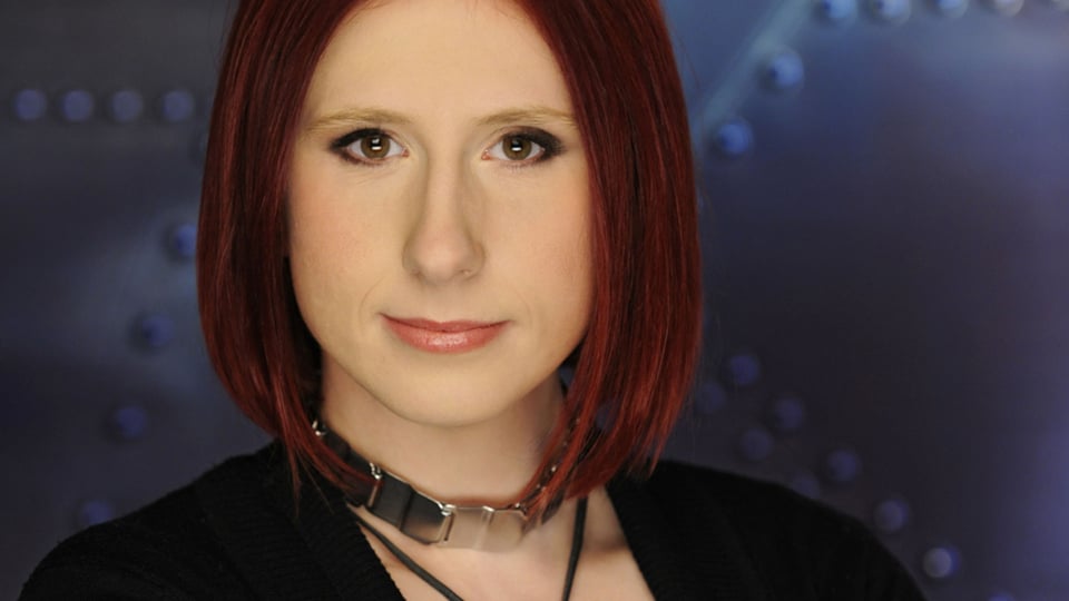 Pressefoto der Kriminalpsychologin Lydia Benecke, Porträt vor dunklem Hintergrund.