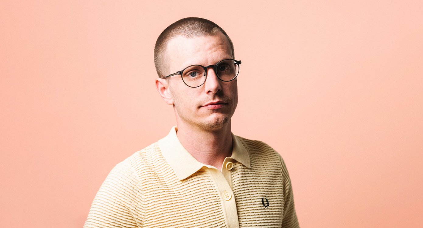 Mann mit Brille vor rosa Hintergrund