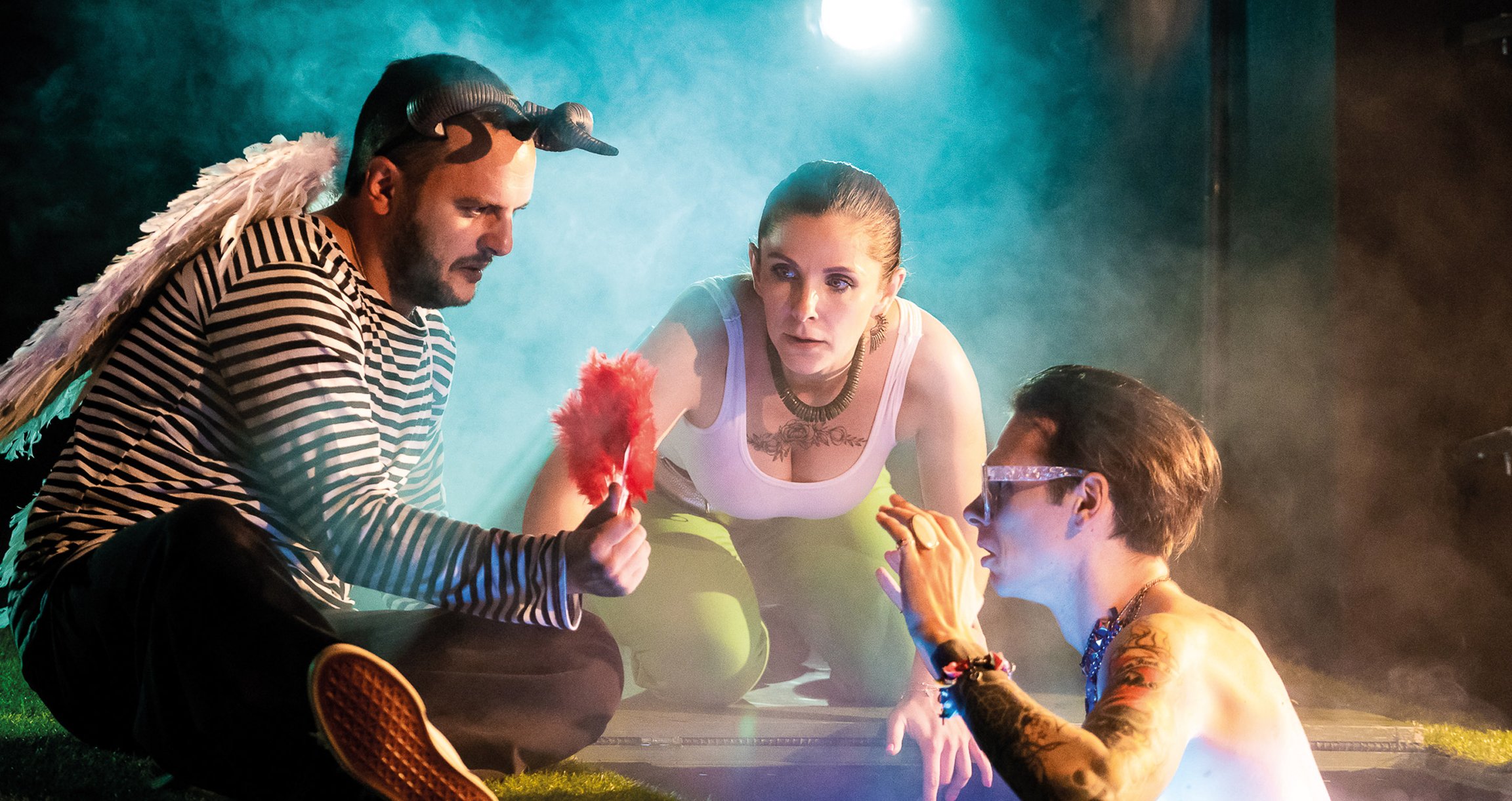 Zwei Männer und eine Frau mit Theaterrequisiten 