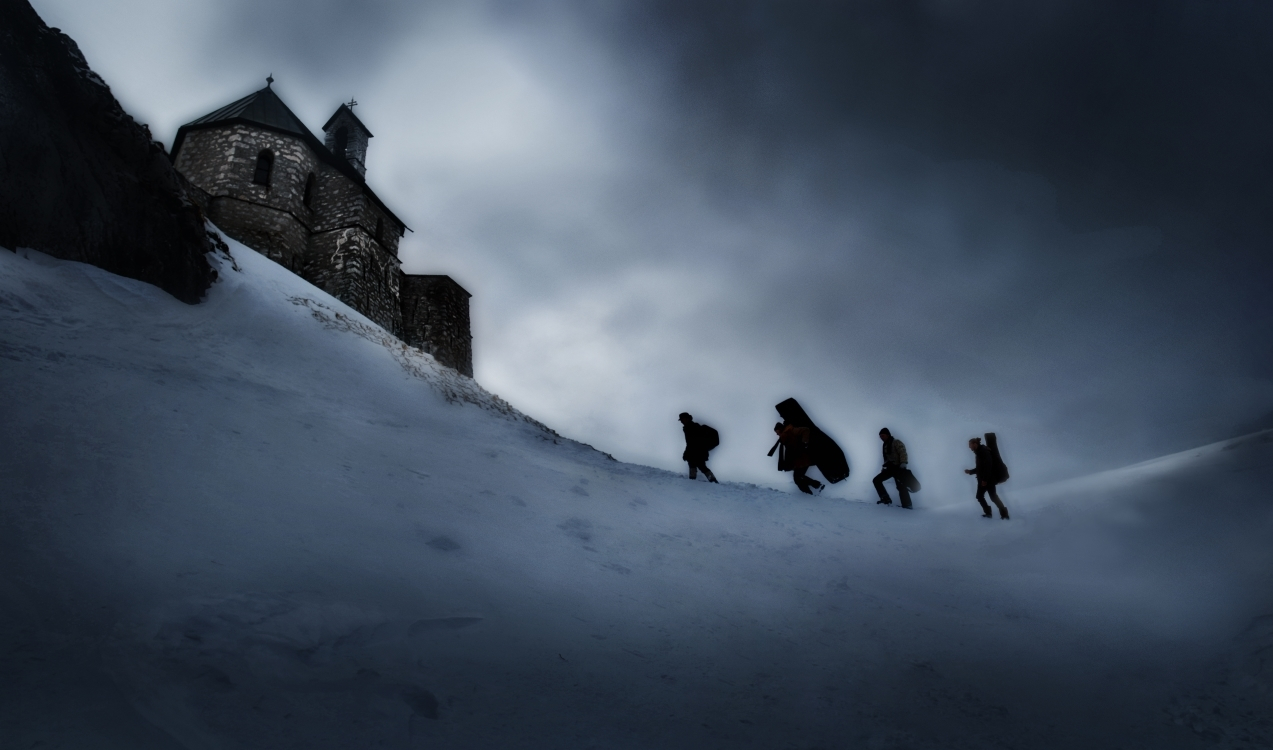 ein Foto einer verschneiten Landschaft mit vier Personen, die einen verschneiten Weg zu einem Haus hinaufgehen