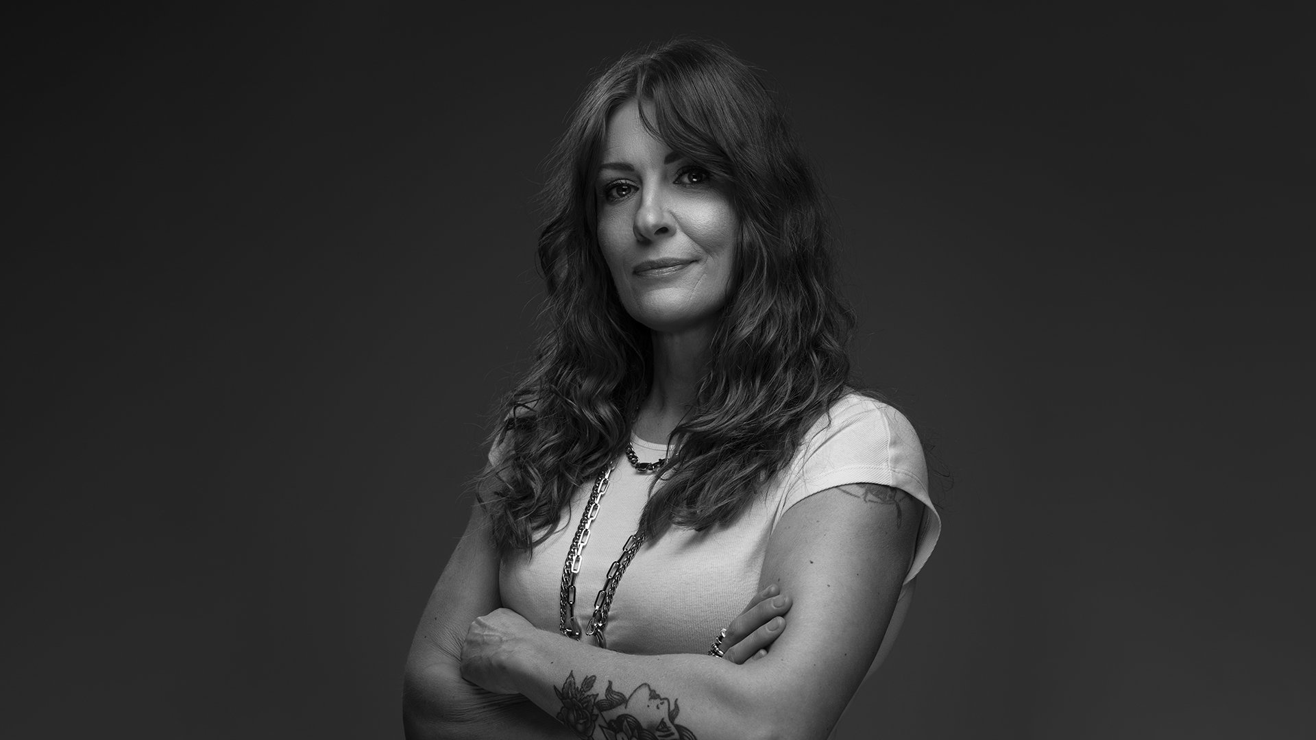 schwarz weiß Bild der Künstlerin in einem weißen T-Shirt mit dunklem Hintergrund