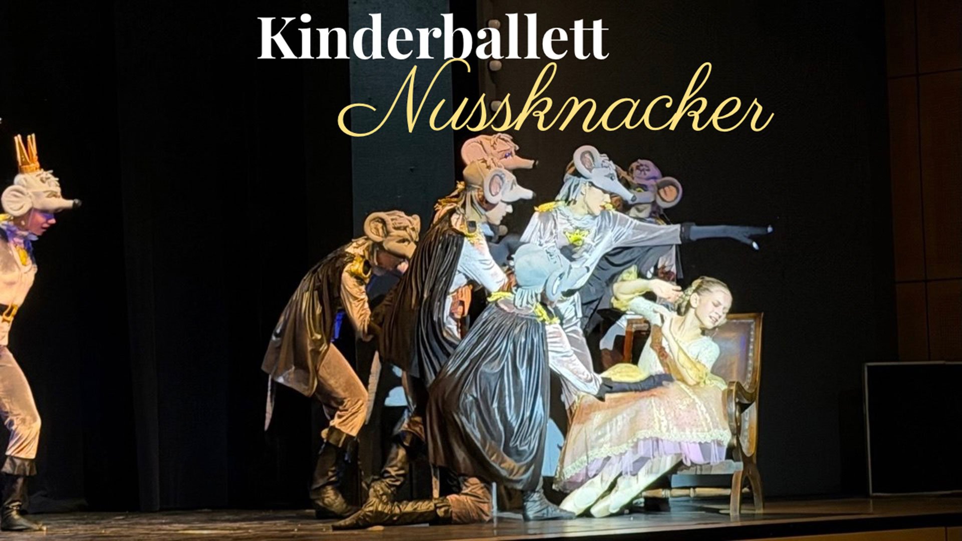Ein Bühnenbild mit Rewuisiten und den Darstellern des Kindeballetts sowie Aufschrift des Titels