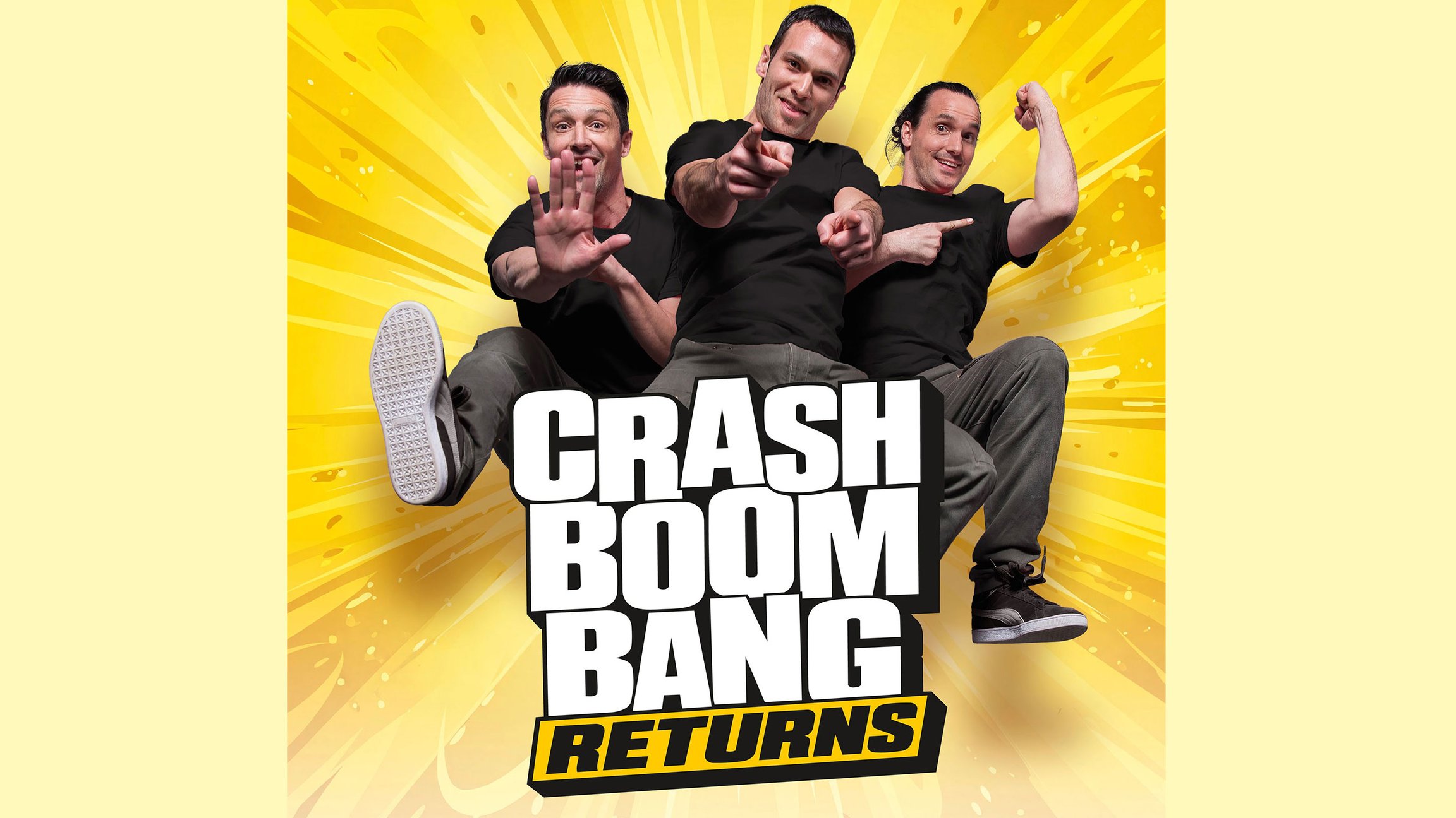 Drei Personen in schwarzen T Shirts posieren vor gelbem Hintergrund mit Comicgrafik. Auf dem Bild steht die Aufschrift Crash Boom Bang Returns.