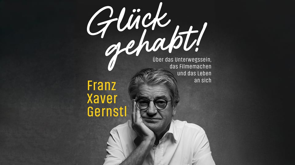Plakat Glück gehabt! von Franz Xaver Gernstl mit Schwarzweißporträt einer Person in weißem Hemd und runder Brille, den Kopf auf eine Hand gestützt, vor dunklem Hintergrund sowie Titel und Untertitel zum Unterwegssein, Filmemachen und Leben.